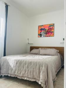 a bedroom with a bed with a painting on the wall at LOGEMENTS ACCÈS PISCINE - T2 Résidence Serena in Cuttoli-Corticchiato +22 photos