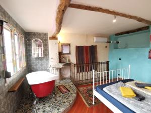 a bathroom with a tub and a bed in a room at CASA DEL ARTE casa rural in Chulilla