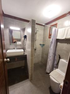 uma casa de banho com um lavatório, um WC e um chuveiro em Nirvana Beach Resort em Boracay
