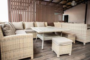 a patio with wicker furniture and a table and chairs at Miki House in Chumphon