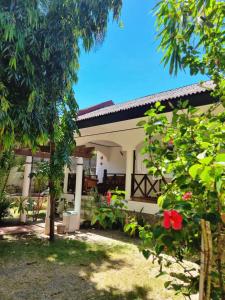 Una casa blanca con un árbol delante. en Nirvana Beach Resort, en Boracay
