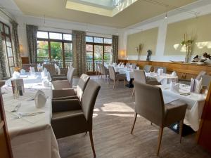 a dining room with white tables and chairs at Simon - das Vitalhotel in Bad Tatzmannsdorf