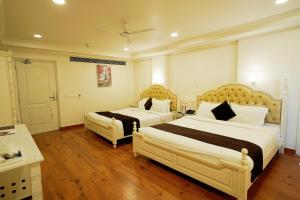 2 letti in una camera d'albergo con pavimenti in legno di Hotel Magenta Jaipur a Jaipur
