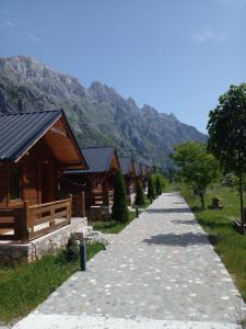 a path leading up to a row of wooden buildings at CNTR PARK VALBONa in Valbonë