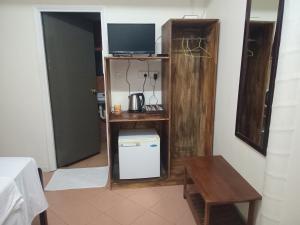 Zimmer mit einem Tisch und einem Regal mit einem TV in der Unterkunft Sunset Lodge in Savusavu