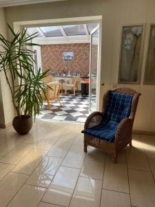 ein Wohnzimmer mit einem Stuhl und einer Pflanze in der Unterkunft Haus - Neue Düne in Dankern
