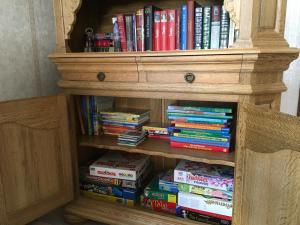 ein mit Büchern gefülltes Bücherregal aus Holz in der Unterkunft Haus - Neue Düne in Dankern