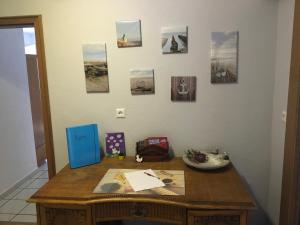 einem Holztisch mit Bildern an der Wand in der Unterkunft Haus - Neue Düne in Dankern