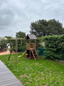 a playground in a yard with a swing at Villa Mirabelle 4 personnes in Châteauneuf-de-Gadagne