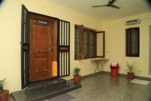 a room with a wooden door and potted plants at UNGA VEEDU PAY AND STAY in Tiruvannāmalai