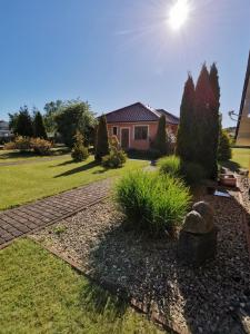a yard with a house and a garden with a rock at Apartamenty Amber Wyspa in Gdańsk