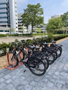 una fila di biciclette parcheggiate l'una accanto all'altra di OZO Hotels Antares Airport a Hoofddorp