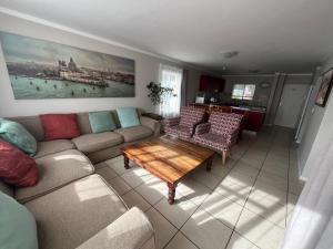 a living room with a couch and a coffee table at Beautiful 3 Bedroom Ground floor apartment - 66 Santini Village in Plettenberg Bay