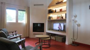 a living room with a television and a table and chairs at Maison typique Basque en pleine campagne in Saint-Pée-sur-Nivelle +13 photos