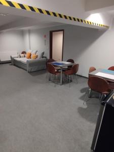 a room with a couch and a table and chairs at Hostel Rakietka in Gdańsk