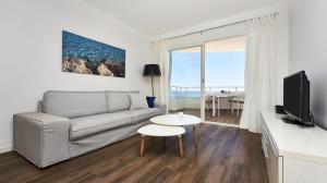 ein Wohnzimmer mit Sofa und Tisch in der Unterkunft Es Sabina in Son Servera