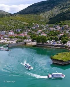 dos barcos en un río con un pueblo en el fondo en four generation hotel en Shirokë