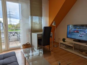 a living room with a television and a glass table at Haus Abendsonne Dachgeschoss klein in Koblenz