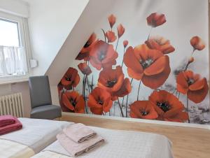 a bedroom with a mural of red flowers on the wall at Haus Abendsonne Dachgeschoss klein in Koblenz