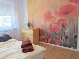 a bedroom with a painting of flowers on the wall at Haus Abendsonne Obergeschoss klein in Koblenz