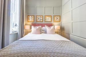 a bedroom with a large white bed with two lamps at No1 Apartments Edinburgh - George IV Bridge in Edinburgh