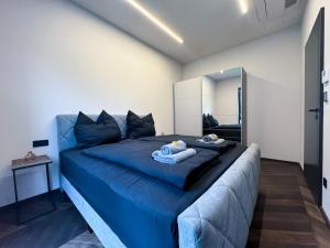 ein großes blaues Bett in einem Zimmer mit Spiegel in der Unterkunft LUXUS-PENTHOUSE mit Weitblick über Graz in Graz
