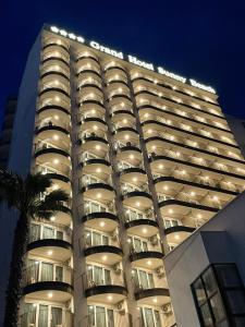 a large white building with balconies at night at Grand Hotel Sunny Beach - All Inclusive in Sunny Beach