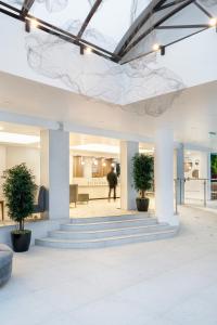 eine Lobby mit Treppen und Topfpflanzen in einem Gebäude in der Unterkunft Grand Hotel Sunny Beach - All Inclusive in Sonnenstrand