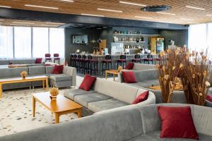 a living room with couches and tables and a bar at Grand Hotel Sunny Beach - All Inclusive in Sunny Beach