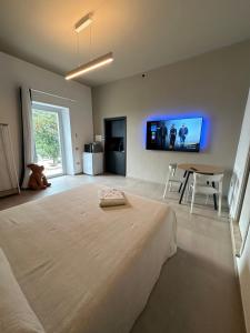 - une chambre avec un grand lit et une télévision murale dans l'établissement MP Luxury room, à Budoni