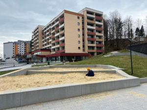 a child sitting in a sandbox in front of a building at Familienfreundliche Ferienwohnung Bayerischer Wald mit Pool in Freyung