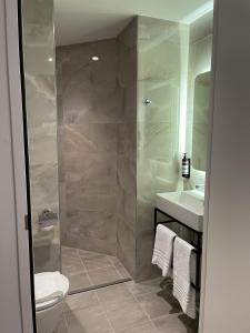 a bathroom with a shower and a toilet and a sink at OZO Hotels Antares Airport in Hoofddorp