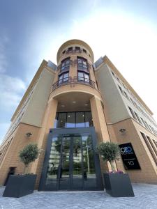 ホーフトドルプにあるOZO Hotels Antares Airportの大きなガラス戸が目の前にある建物