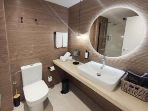 y baño con lavabo y espejo. en Flacalco Hotel & Apartments, en Cala Ratjada