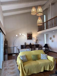 ein Wohnzimmer mit einem gelben Sofa und Kronleuchtern in der Unterkunft Villa Les 3 frères in San-Nicolao