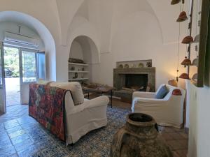 a living room with two chairs and a fireplace at The Place Yoga Retreat *FREE YOGA CLASS in Pantelleria
