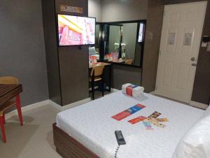 a room with a bed with a television and a table at Hotel Sogo Mindanao Avenue in Manila
