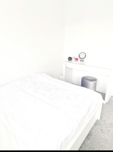 Un dormitorio blanco con una cama y una mesa. en 3 Bedroom House London, en Harrow