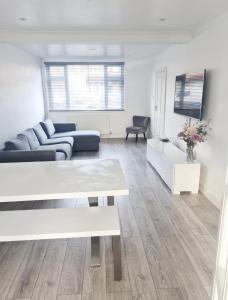 una sala de estar con un sofá y una mesa en 3 Bedroom House London, en Harrow 2 fotos más