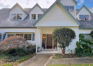 a white house with a door and a tree at 5Rooms life-style in City—“Golden Harvest Retreat” in Matangi