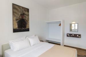 1 dormitorio con 1 cama con una pintura en la pared en UtopOia Apartment, en Oia