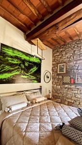 a bedroom with a bed and a stone wall at La Casa Stregatta in Sassetta
