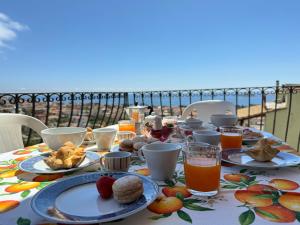 a table with plates of food and drinks on a balcony at Casa Giliè A in Santa Maria Navarrese +9 photos