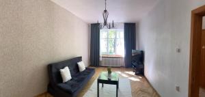 - un salon avec un canapé noir et une table dans l'établissement Danes Square apartments with River View, à Klaipėda