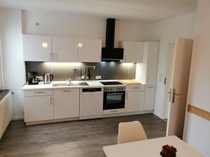 Gästehaus Koblenz Obergeschoss في فالندار: مطبخ بخزائن بيضاء وفرن موقد +9 صور