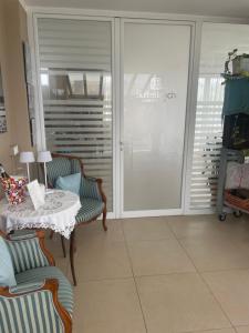Habitación con mesa, sillas y puerta corredera de cristal. en SUITEBEACH b&b and resort, en Marsala
