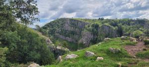 a mountain with rocks and trees on a hill at Cottage in Wells in Wells