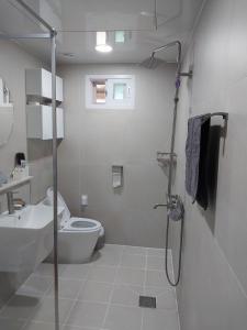 uma casa de banho com um chuveiro, um WC e um lavatório. em Calmers em Pohang