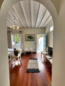 una sala de estar con un arco y una habitación con una cama y una mesa en Le Coq Apartments, en Mykonos ciudad