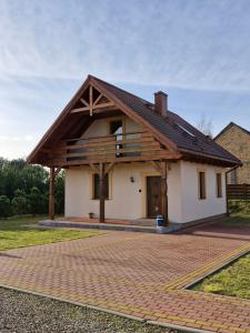 una casa con techo de madera en una entrada de ladrillo en Żwirowa Góra - Domki nad Narwią, en Tykocin